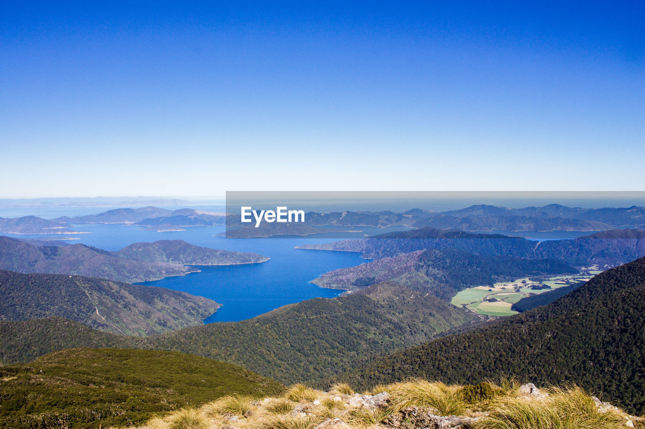 SCENIC VIEW OF LAKE AND MOUNTAINS AGAINST BLUE SKY