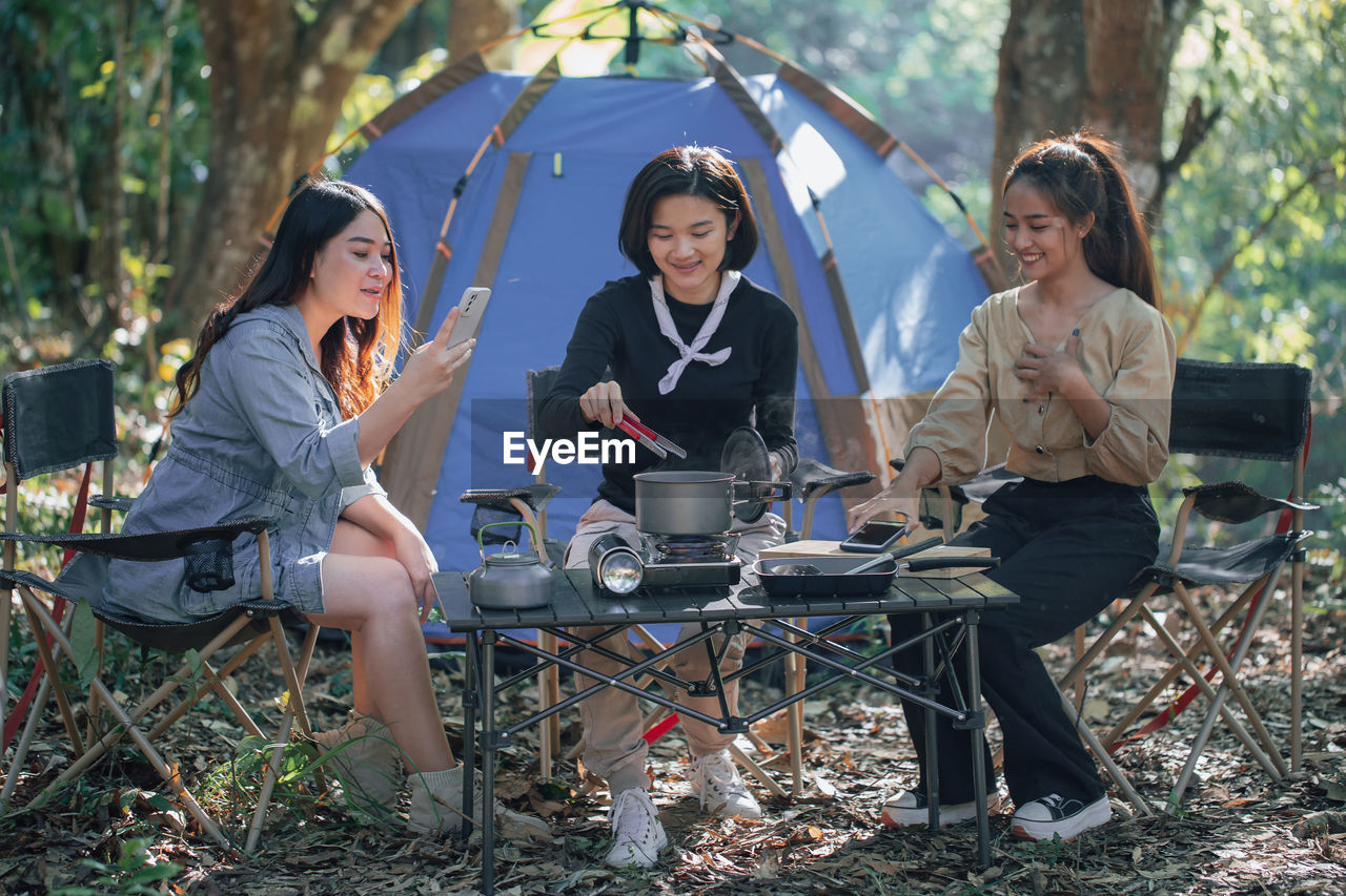 Three bestie go camping in the forest and take a photos while cooking