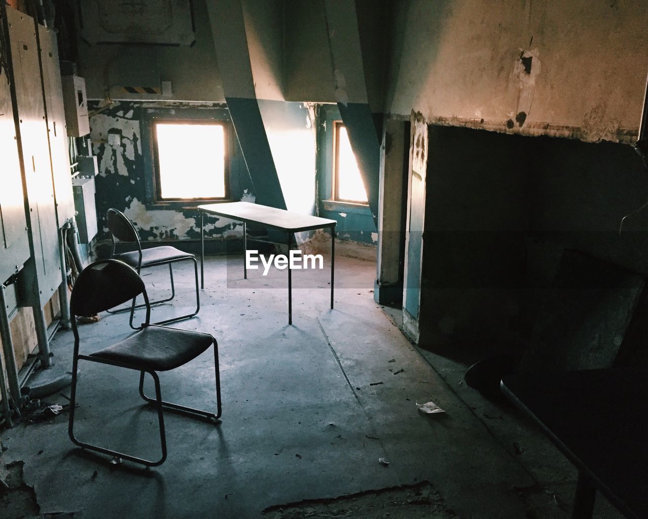Chairs in an abandoned room with windows