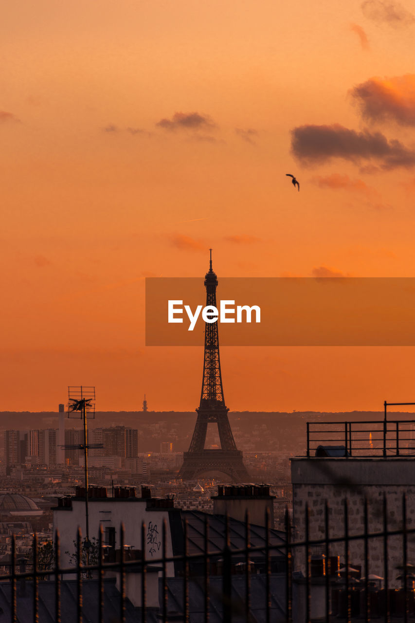 Aerial view of eiffel tower against sky in city during sunset