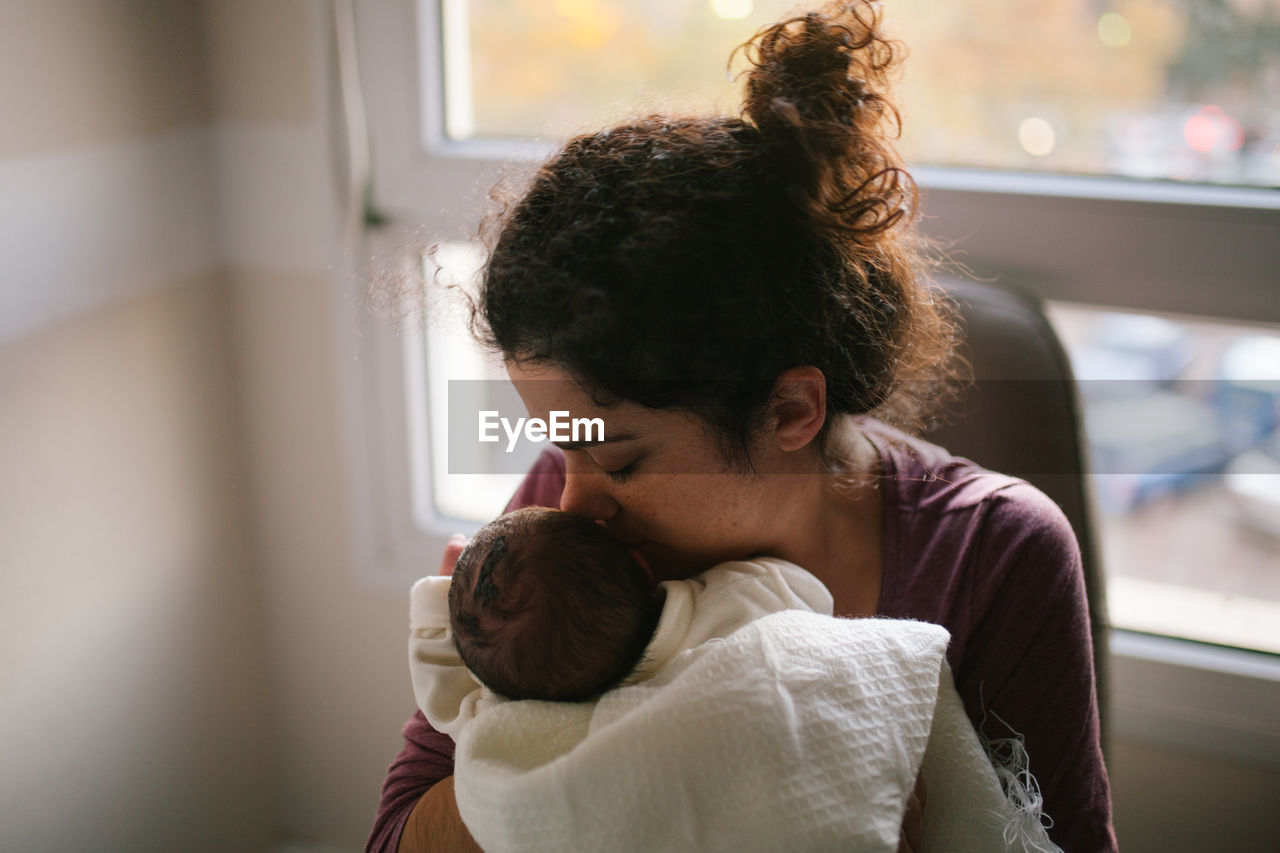 Mother kissing daughter at home