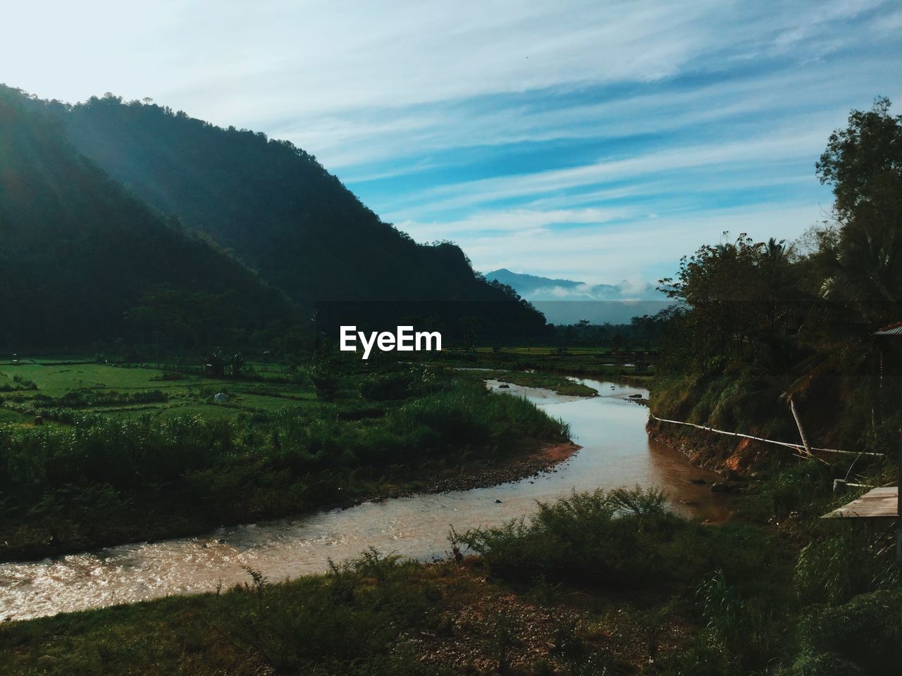 Scenic view of river against cloudy sky