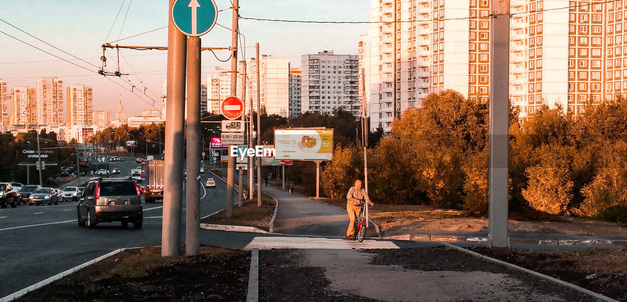 PEOPLE ON CITY STREET BY BUILDINGS