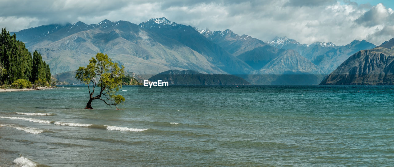 SCENIC VIEW OF SEA AGAINST MOUNTAINS