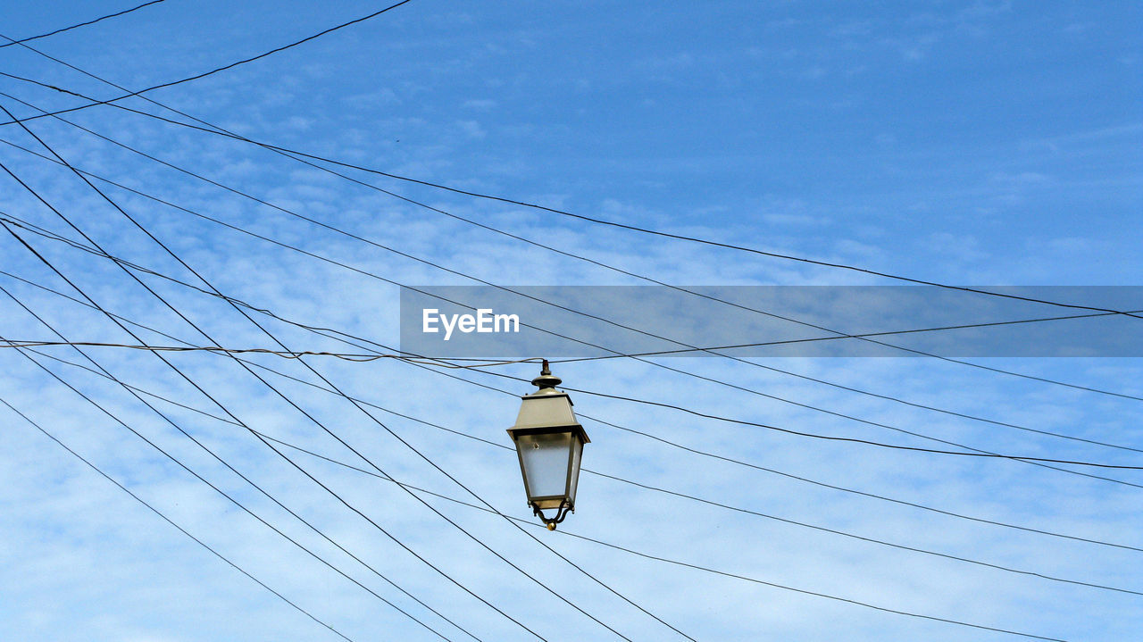 Low angle view of street light against blue sky