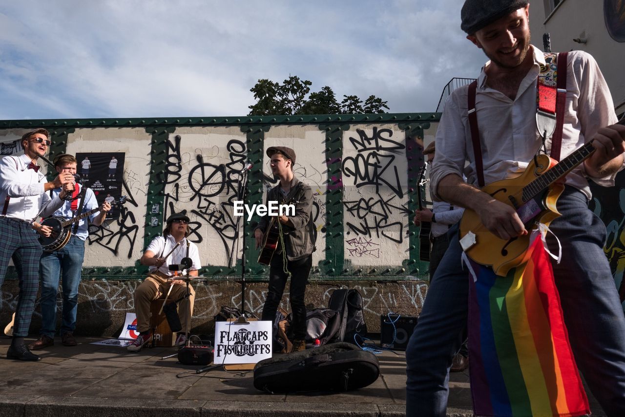 MEN PLAYING GUITAR AGAINST THE SKY