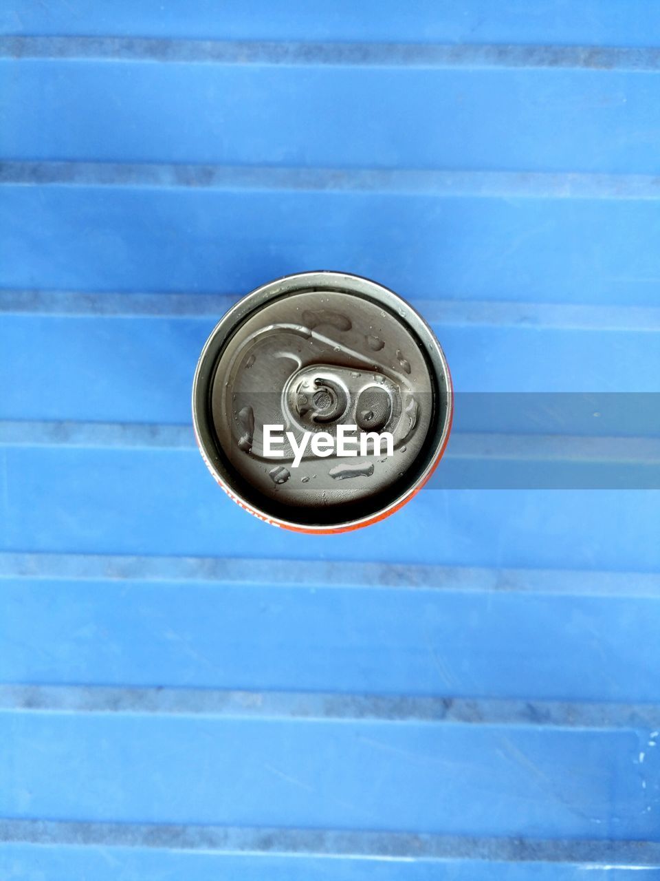Directly above shot of drink can on blue bench