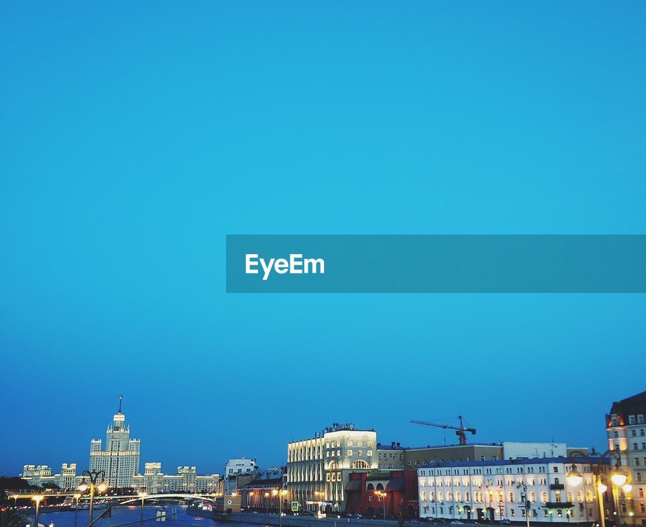 Buildings in city against clear blue sky