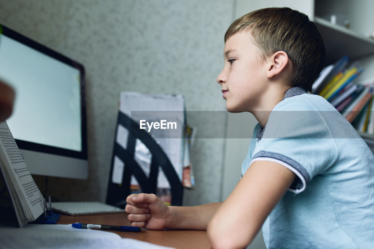 Side view of boy using computer