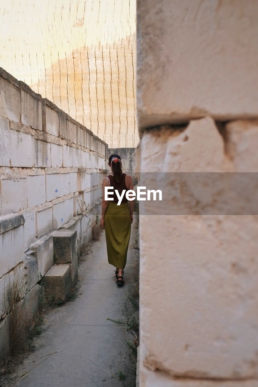 Rear view of women standing against wall