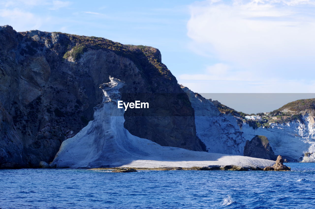 SCENIC VIEW OF SEA AGAINST MOUNTAIN