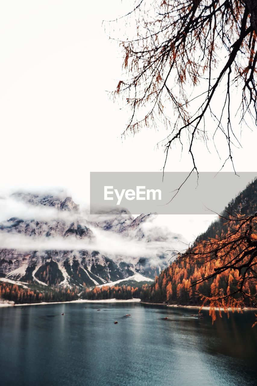 Scenic view of river by mountains against clear sky