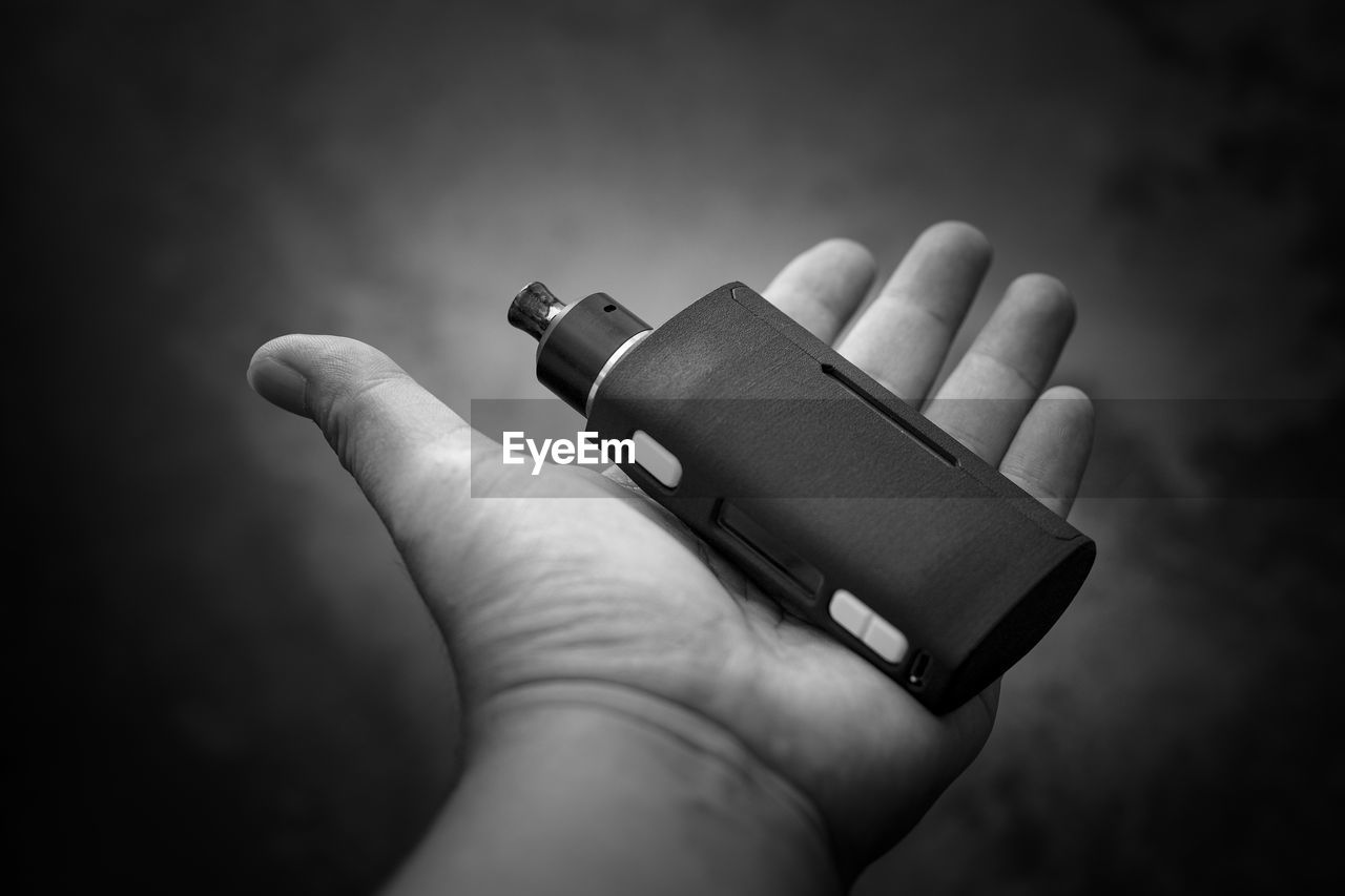 Cropped hand of person holding electronic cigarette