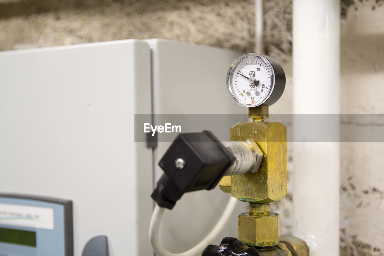 CLOSE-UP OF CLOCK ON METAL MACHINE