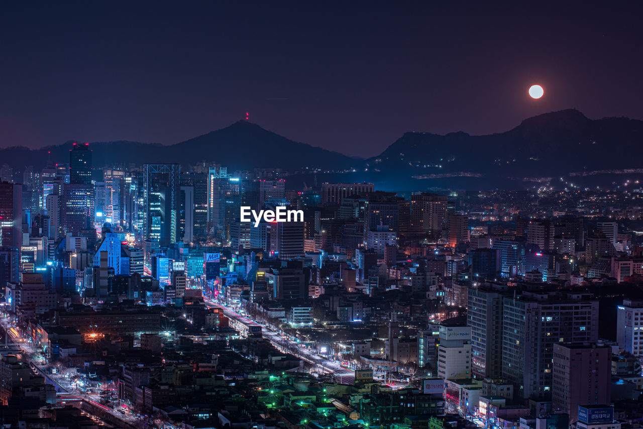 High angle view of illuminated city buildings at night