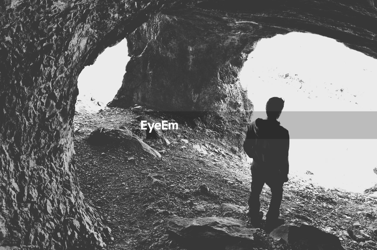 Rear view of man standing in cave