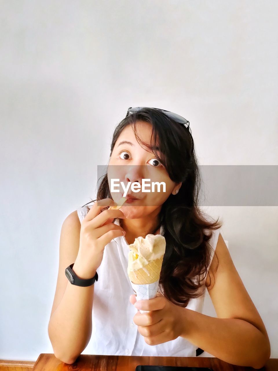 Portrait of a girl enjoying yummy cone ice cream.  