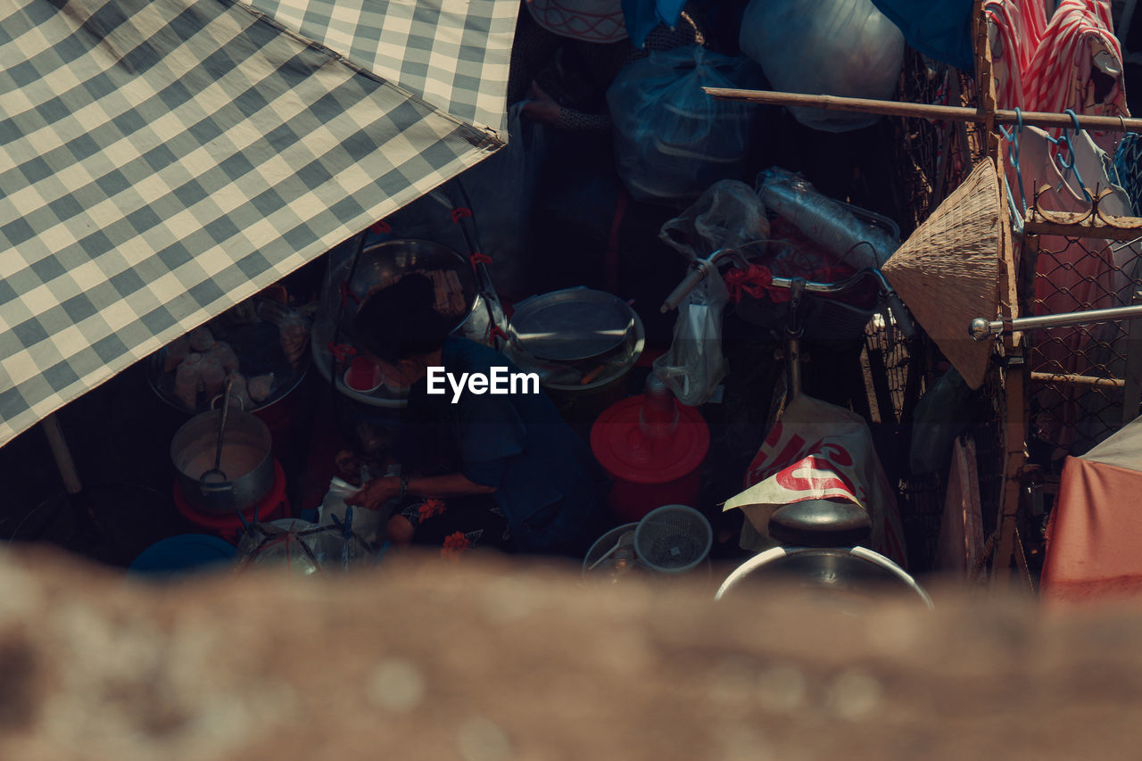 HIGH ANGLE VIEW OF PEOPLE SITTING AT MARKET