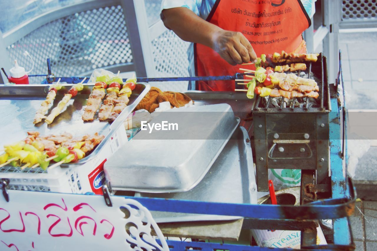 MAN PREPARING FOOD AT MARKET STALL