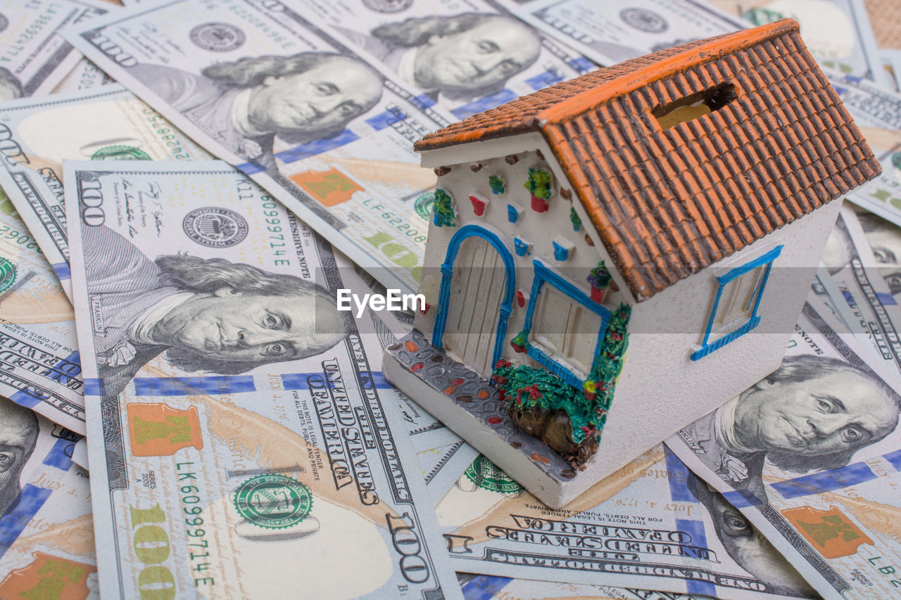High angle view of toy house and paper currencies