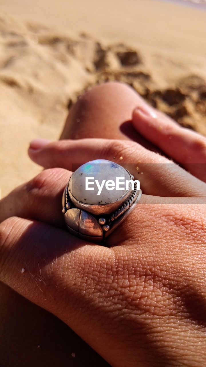 Close-up of woman wearing ring at beach
