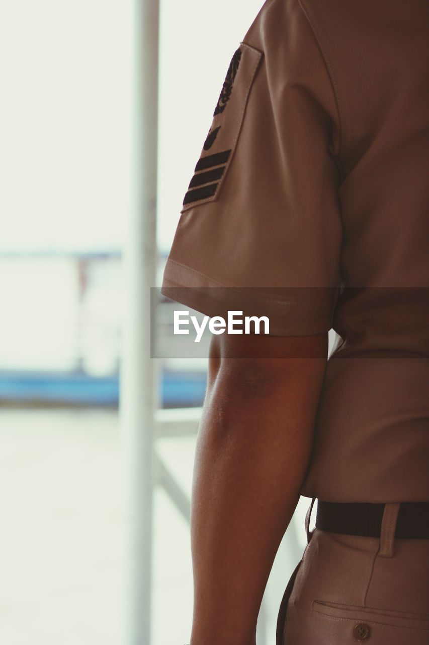 Midsection of person wearing uniform