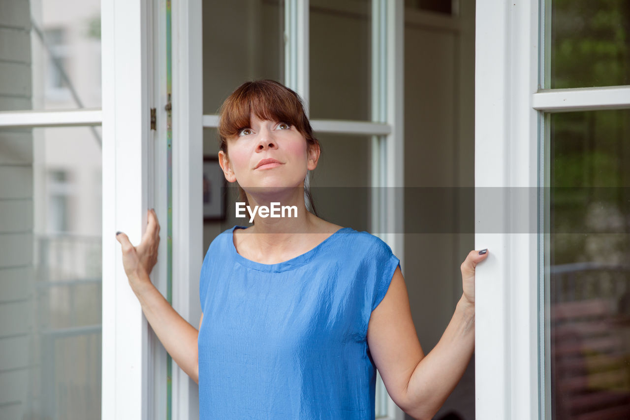 Woman with bangs looking through window