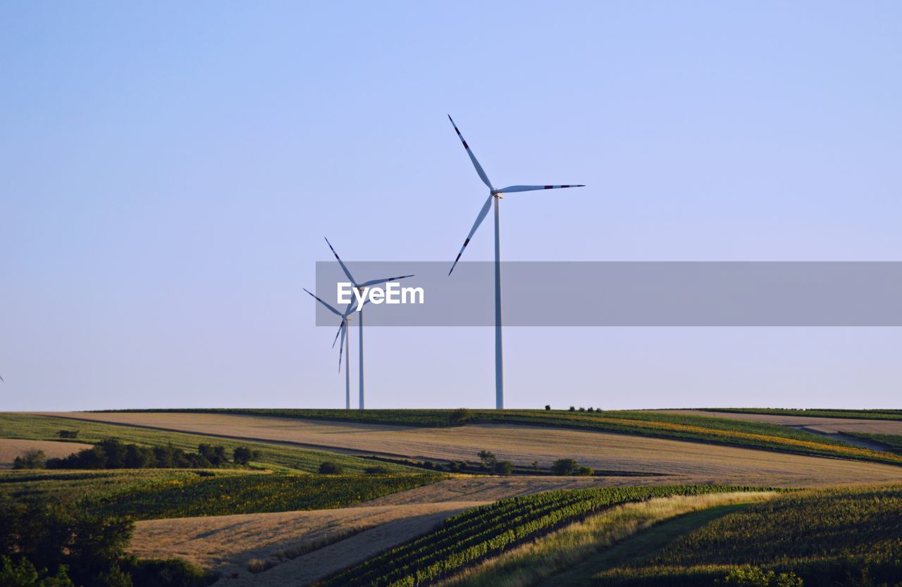 WINDMILL ON FIELD AGAINST CLEAR SKY