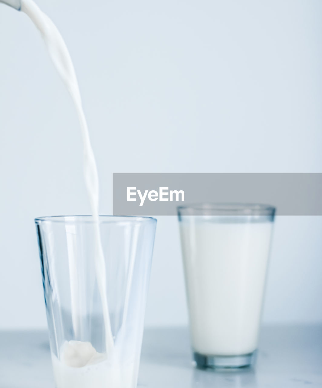 close-up of drinking glasses on table against white background