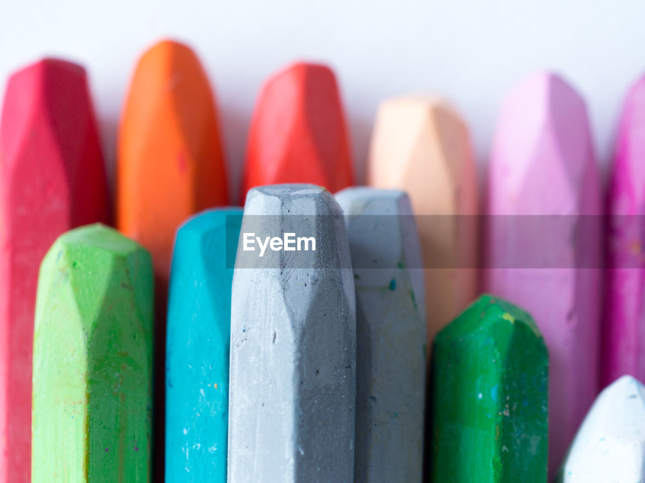 Directly above shot of multi colored pastel crayons on blue background