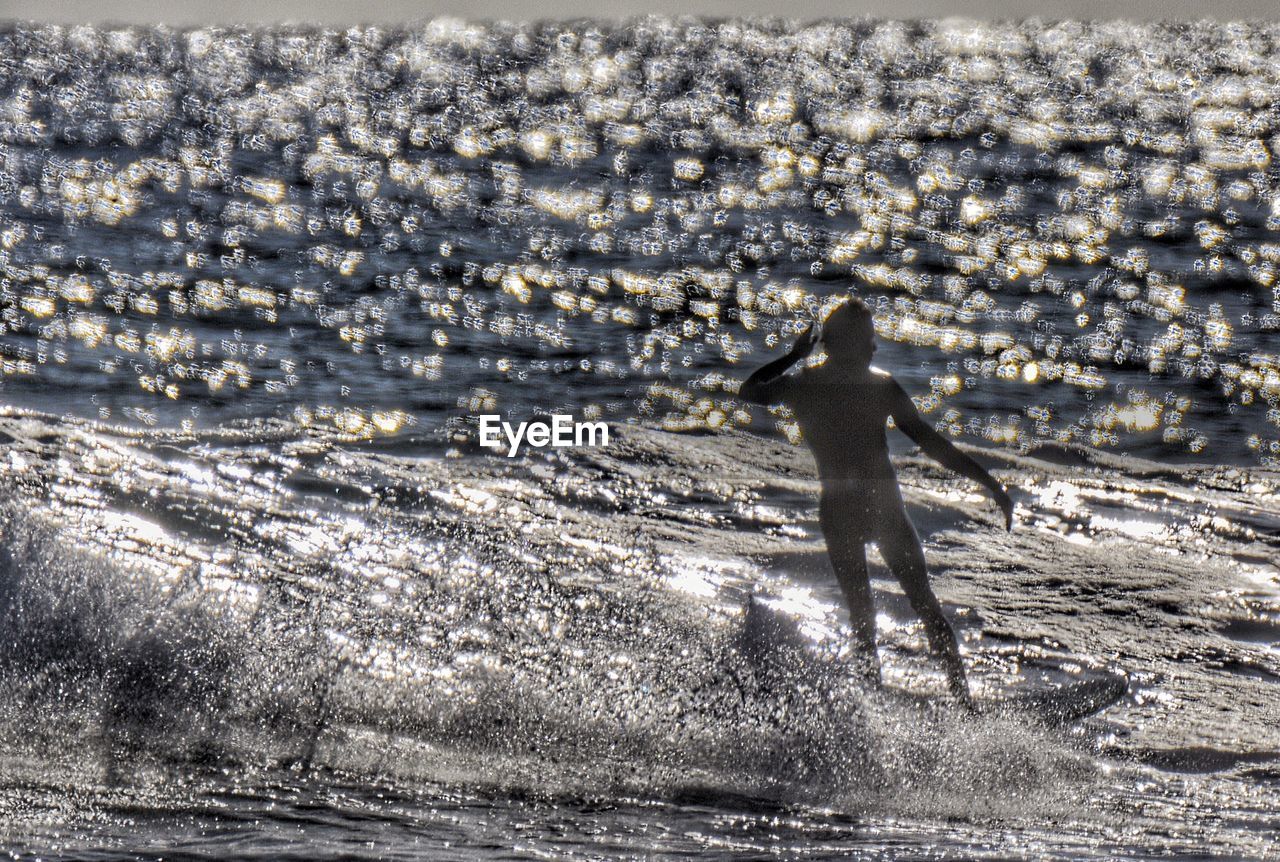 WOMAN STANDING AT SEASIDE