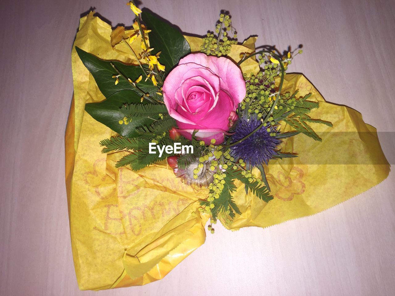 HIGH ANGLE VIEW OF ROSE BOUQUET ON TABLE AGAINST WALL