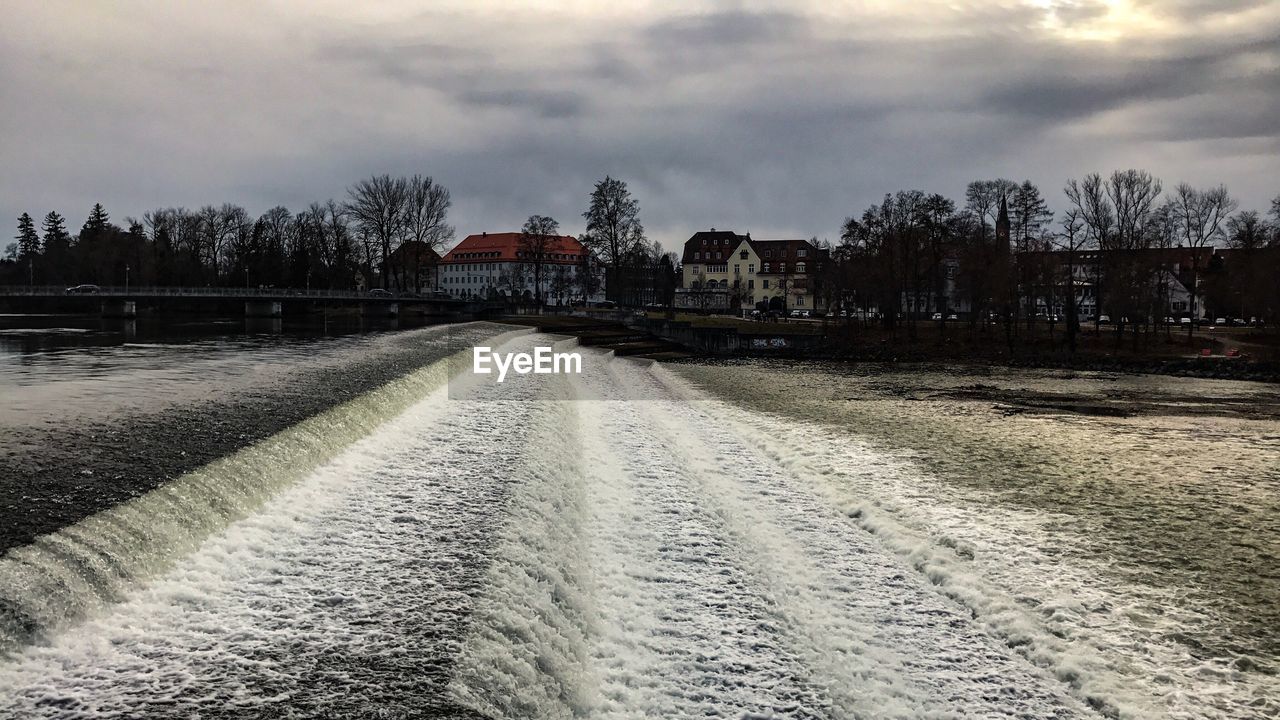 Road amidst houses against sky