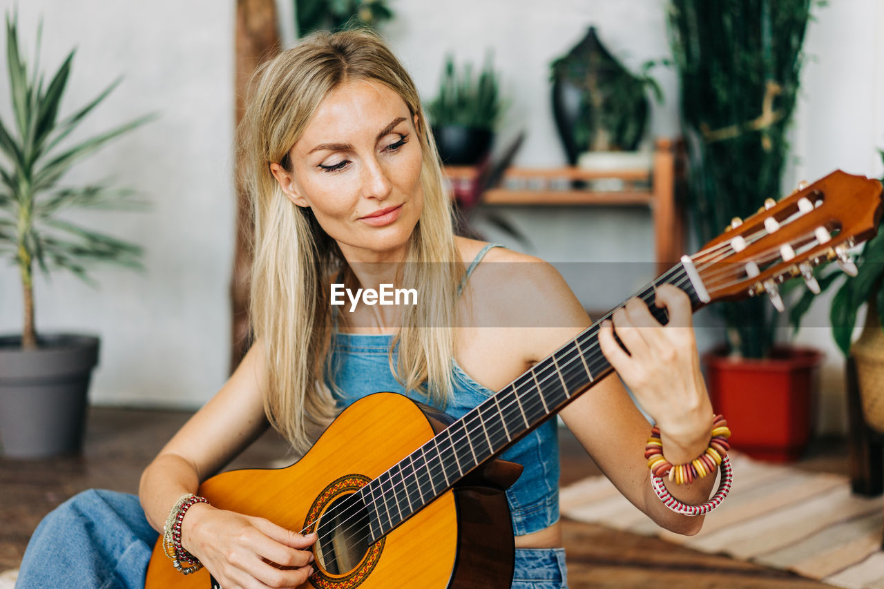 Portrait of romantic woman playing acoustic guitar