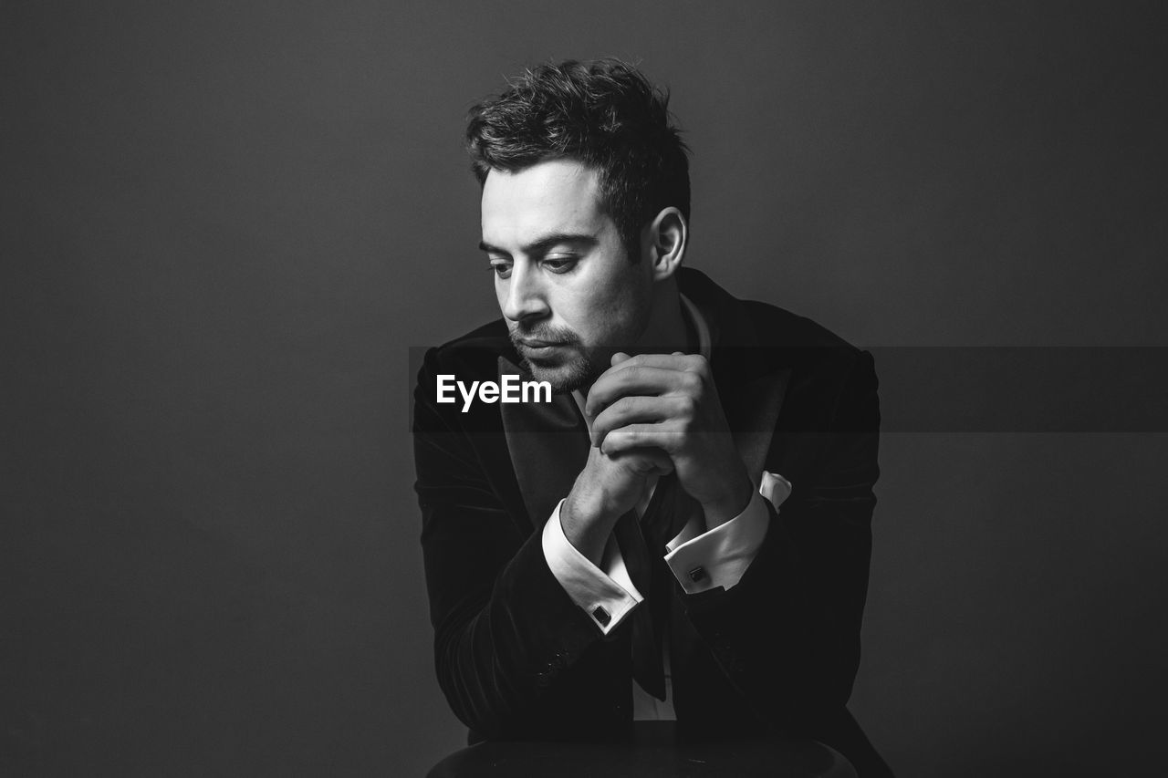 PORTRAIT OF YOUNG MAN OVER BLACK BACKGROUND