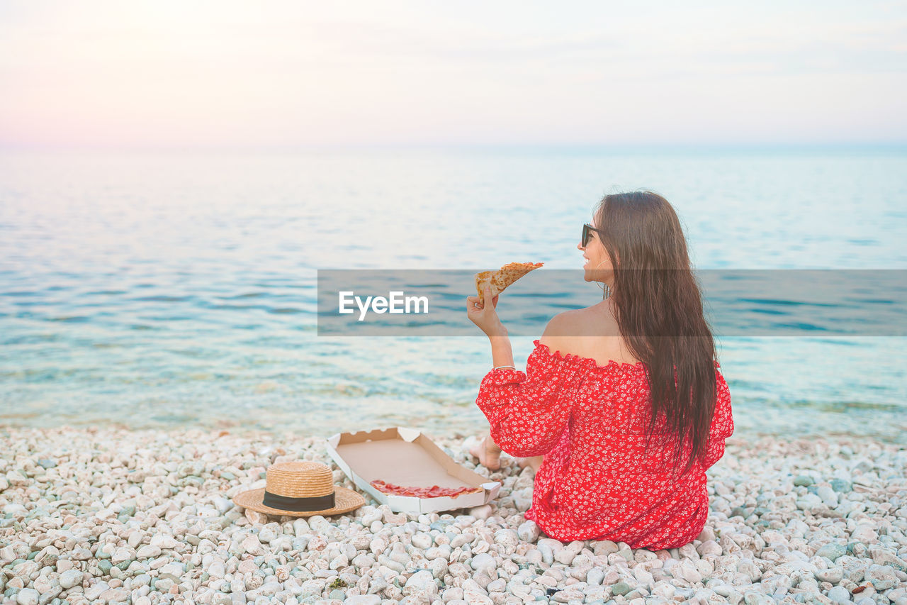 WOMAN ON BEACH AGAINST SKY