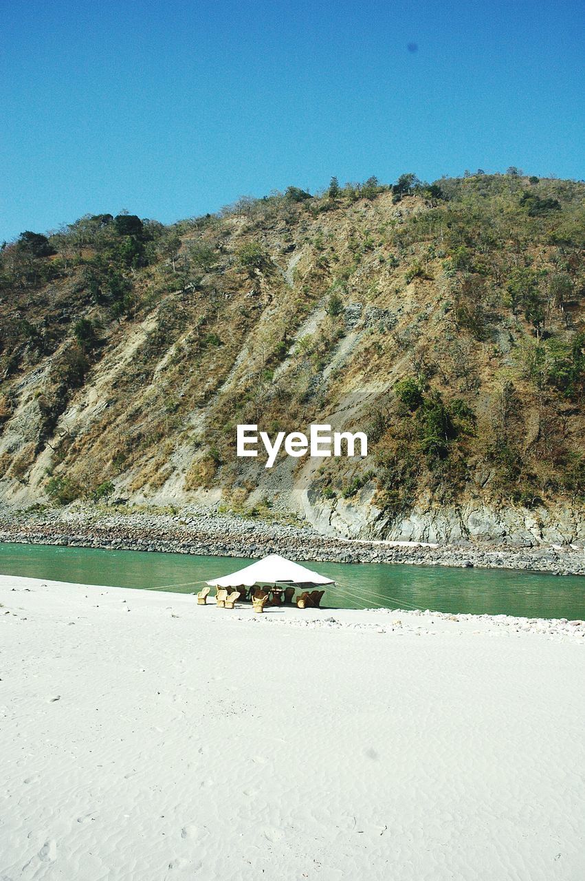 SCENIC VIEW OF RIVER AMIDST TREES AGAINST CLEAR BLUE SKY