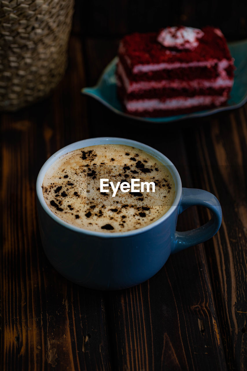 Close-up of coffee cup by cake on table