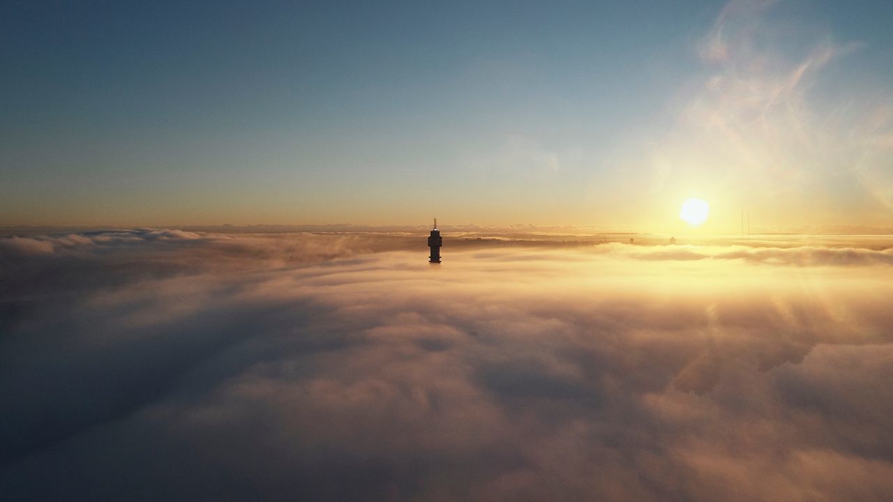 Silhouette tower against cloudy sky during sunset