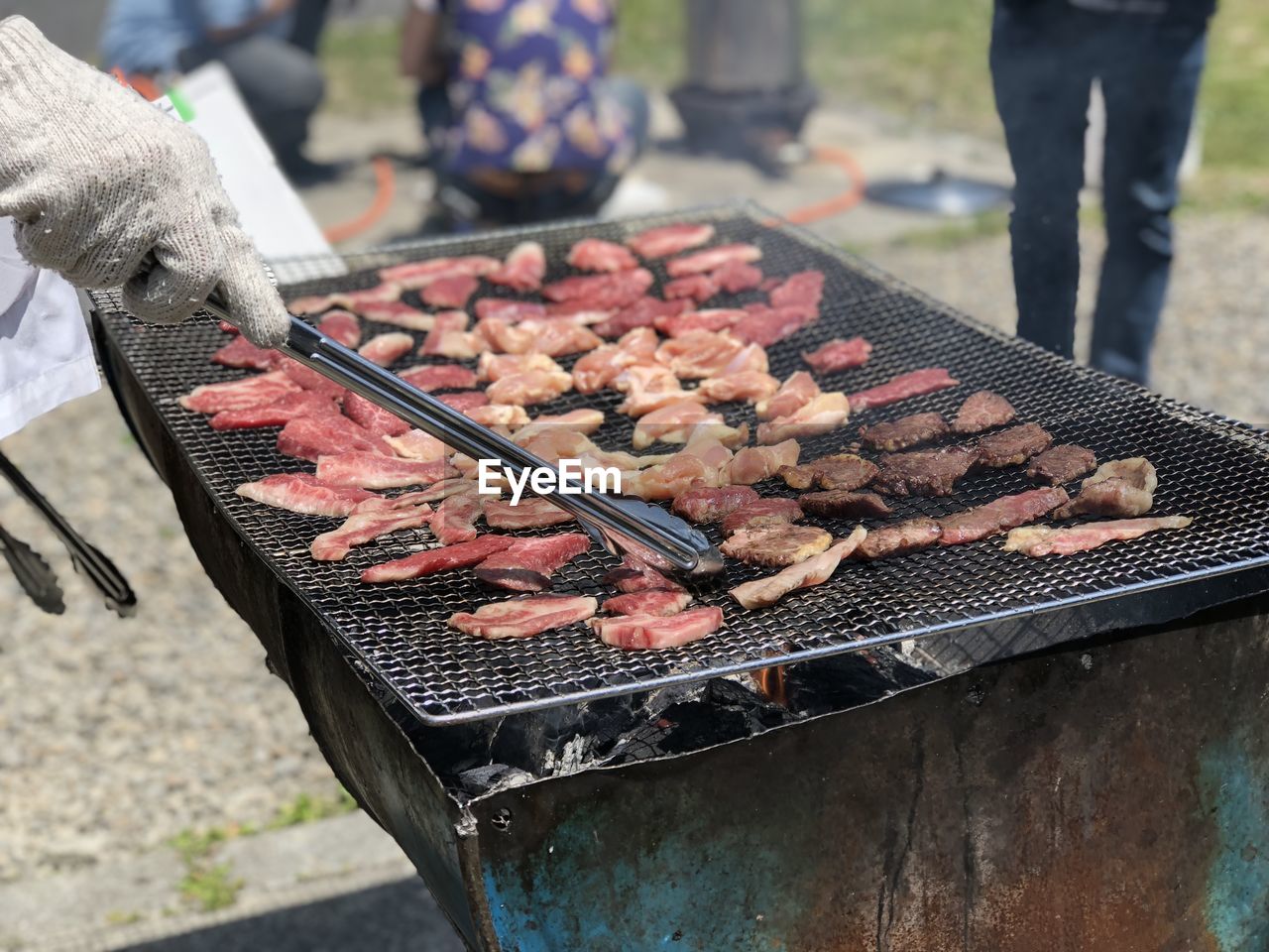 Midsection of man preparing food on barbecue grill