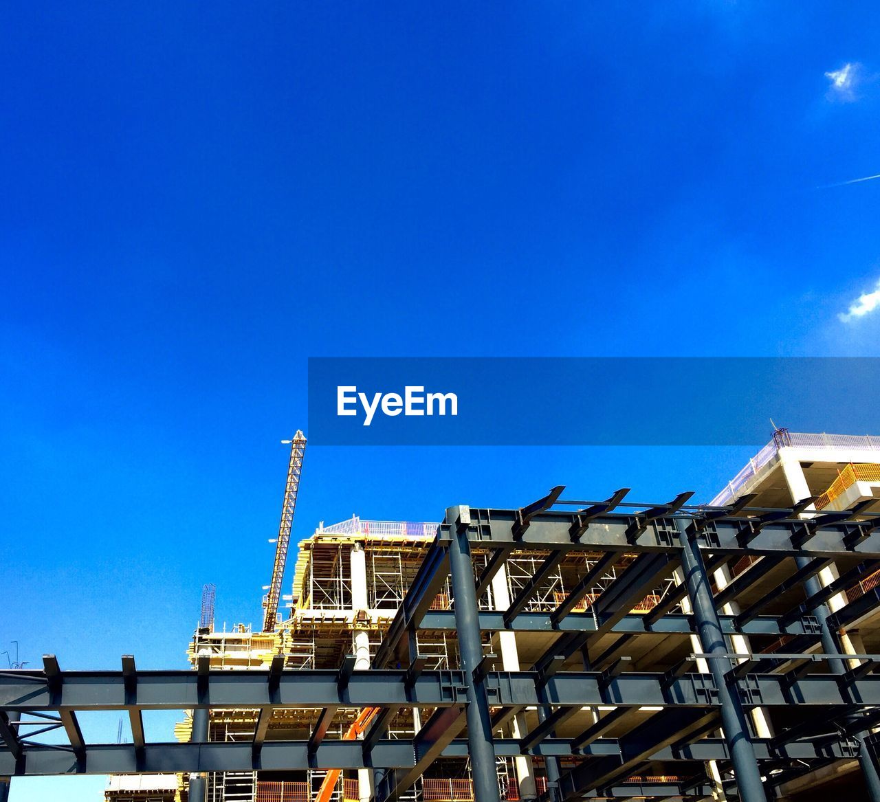 Low angle view of built structure being constructed against clear blue sky