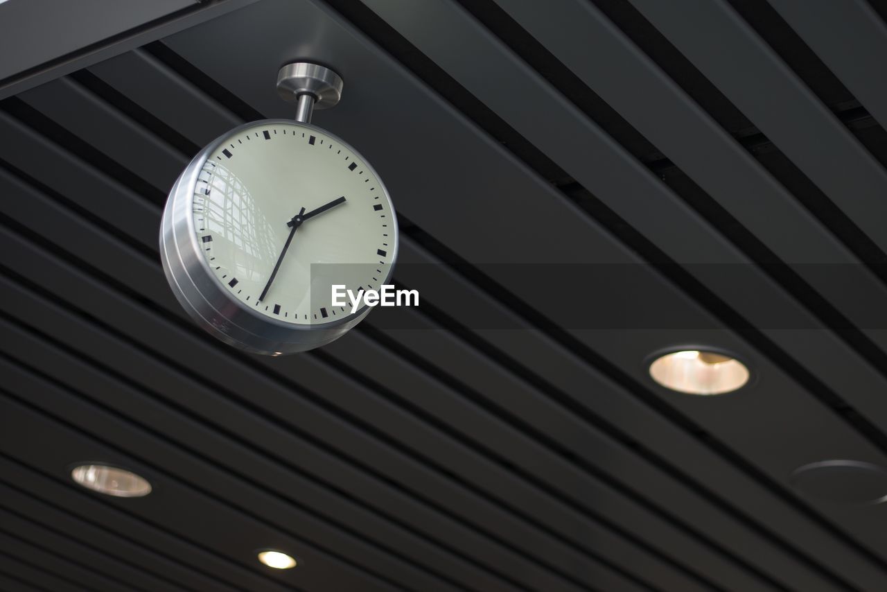 Low angle view of clock hanging on ceiling