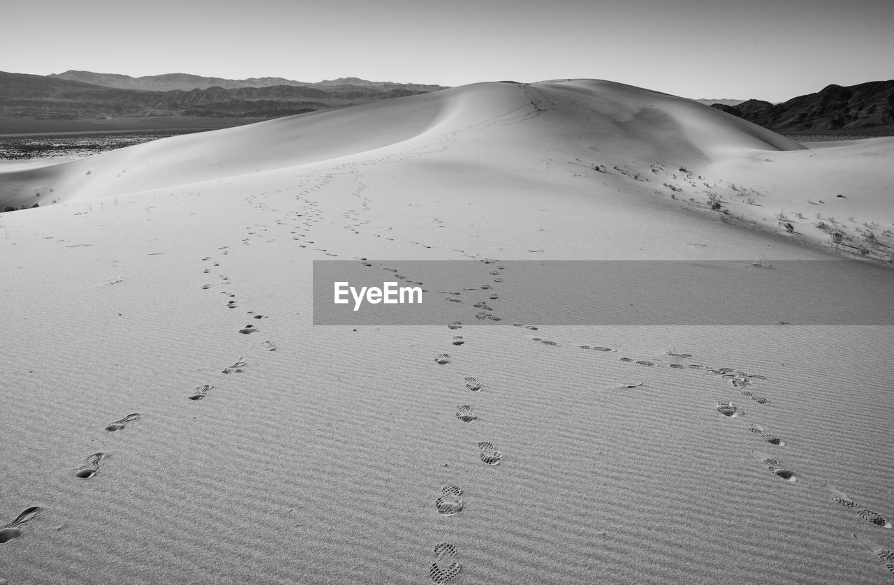 Scenic view of desert footsteps against sky