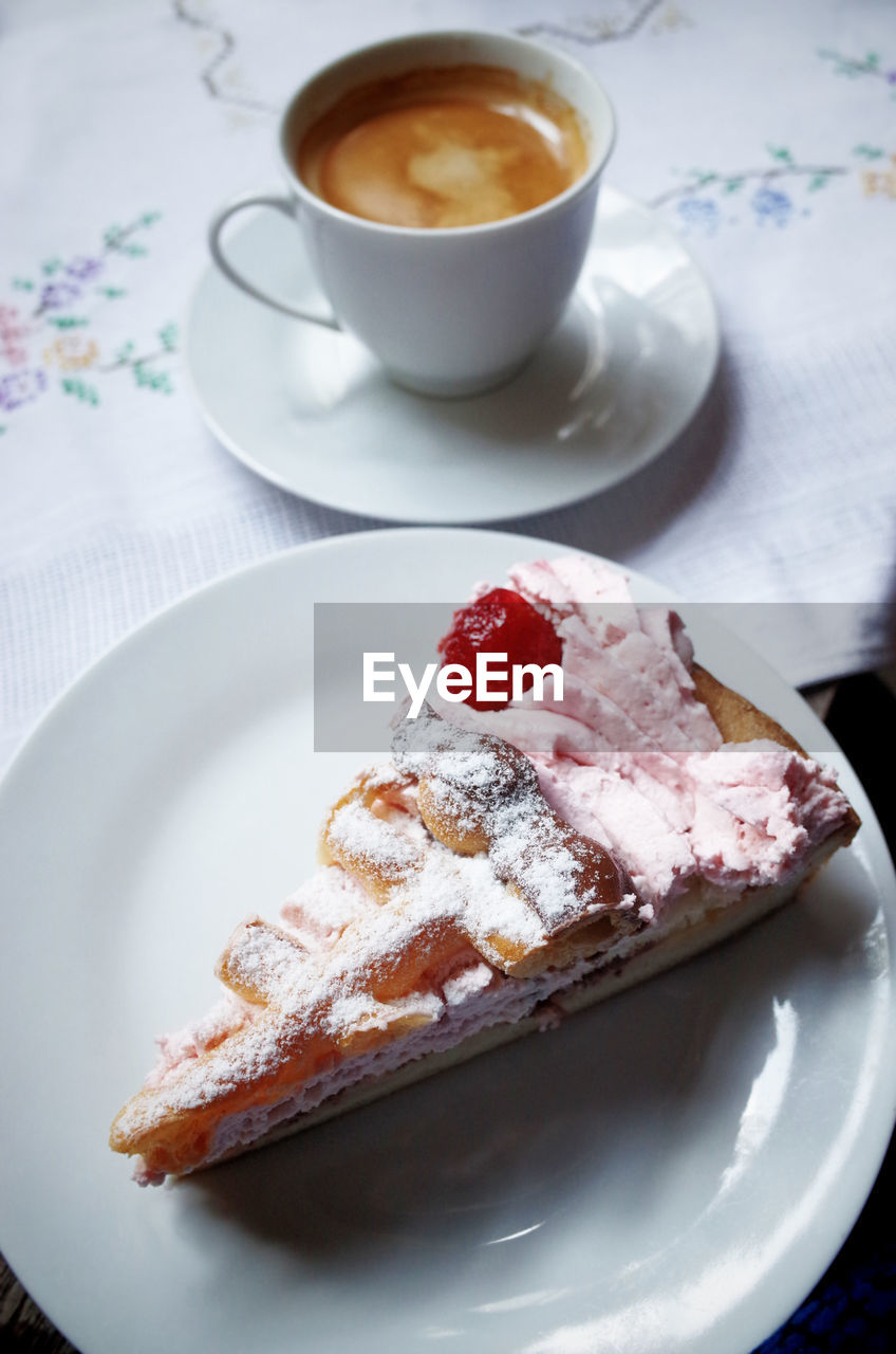 Close-up of cake slice served with tea on table