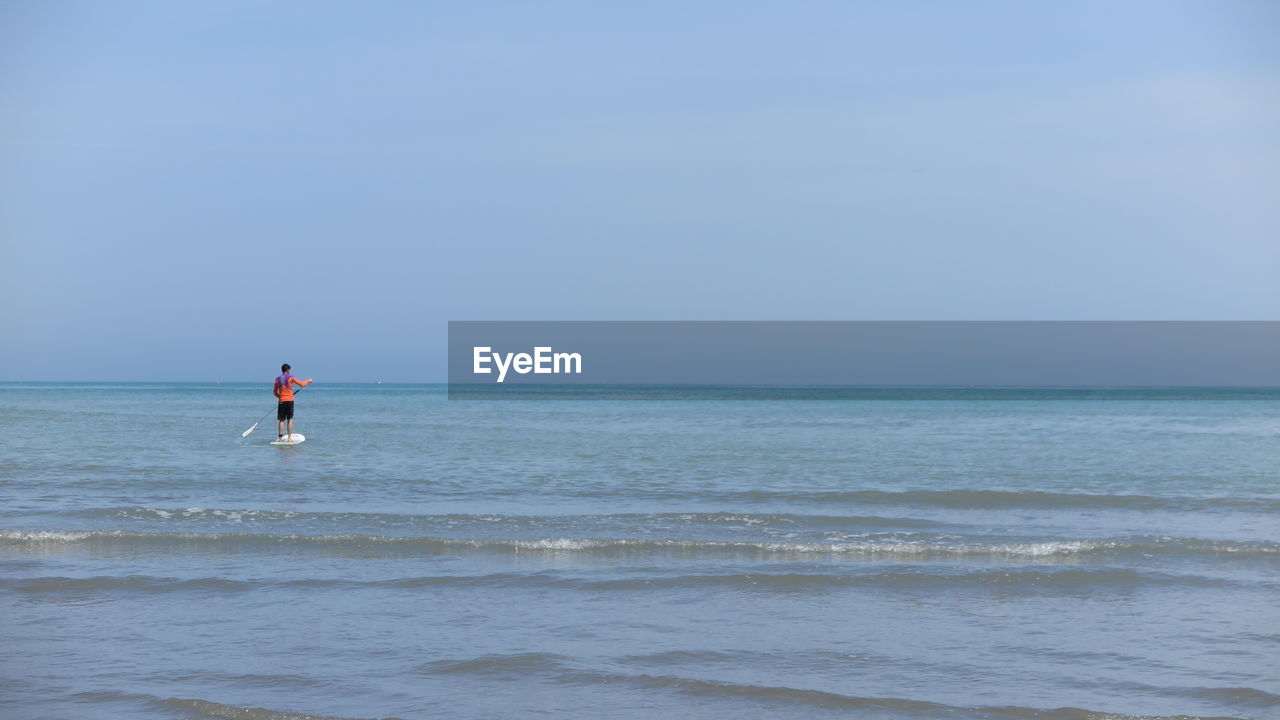 MAN ON SEA AGAINST CLEAR SKY