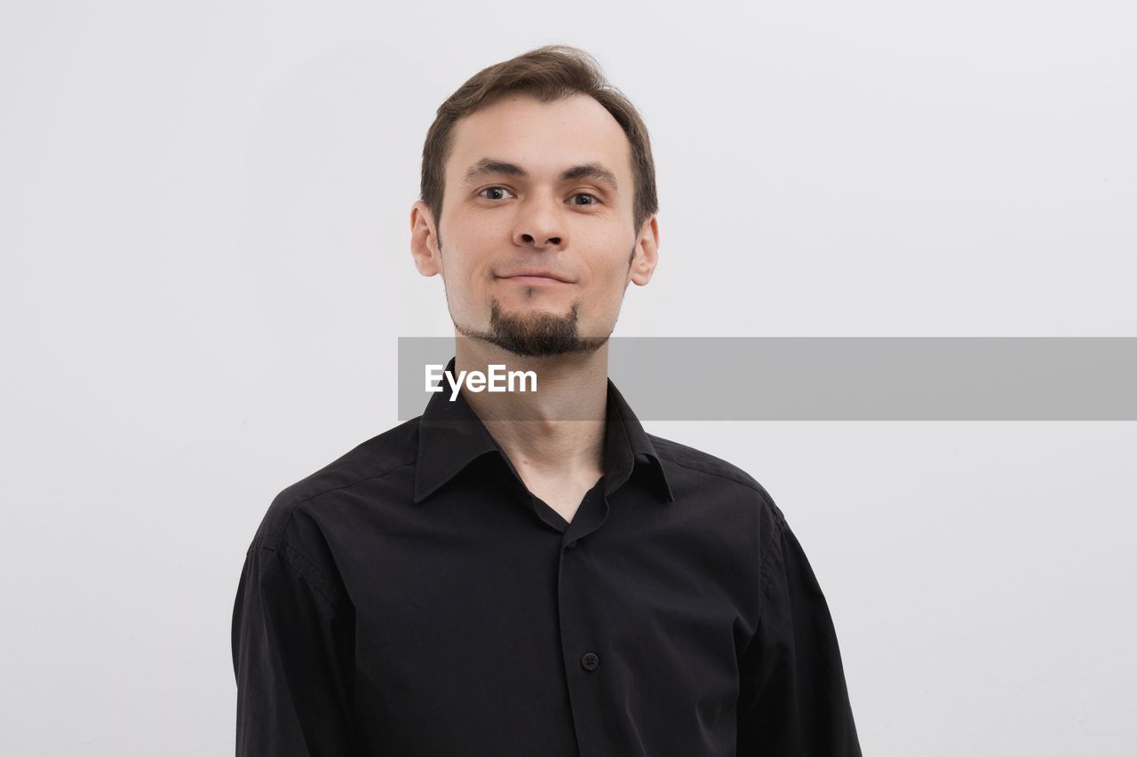 portrait, one person, studio shot, looking at camera, indoors, adult, front view, young adult, clothing, men, headshot, copy space, white background, person, smiling, sleeve, beard, emotion, standing, brown hair, waist up, individuality, facial hair, casual clothing