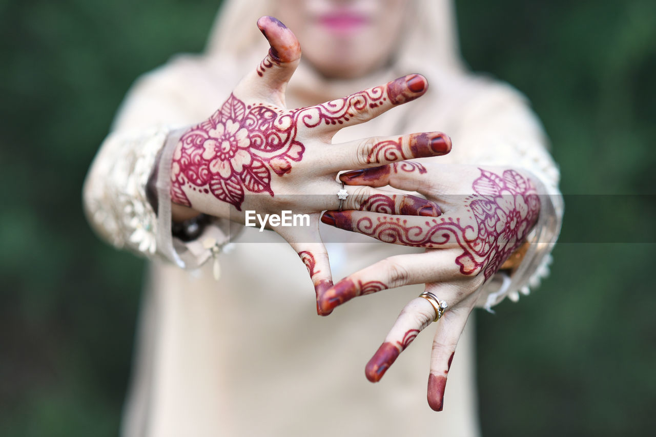 Midsection of bride showing engagement ring while standing outdoors