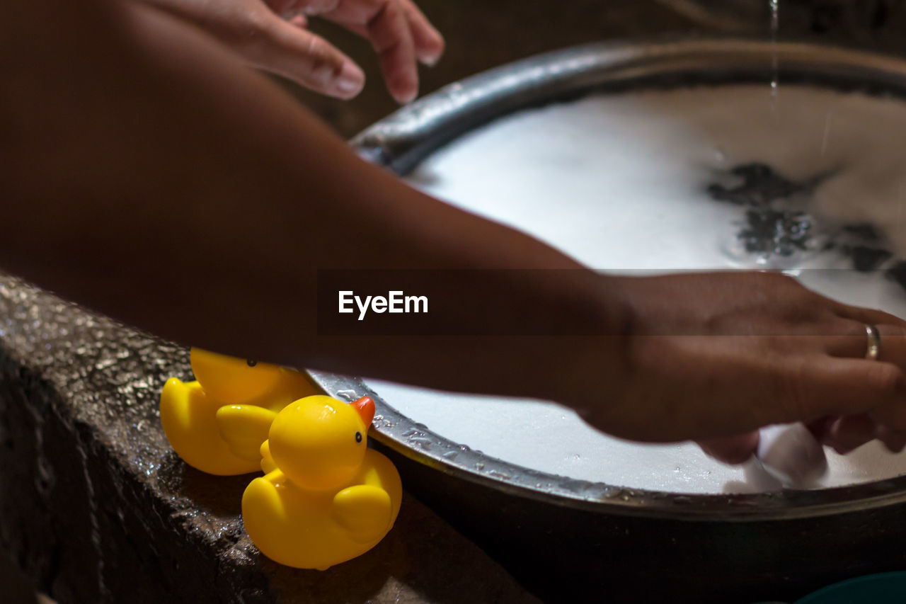 Cropped hand of woman filling water in container