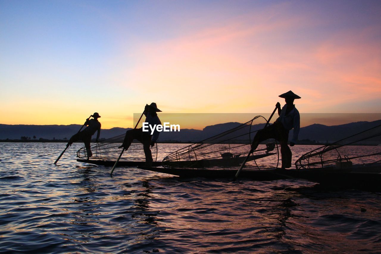 SILHOUETTE PEOPLE ON BOAT AGAINST SKY DURING SUNSET