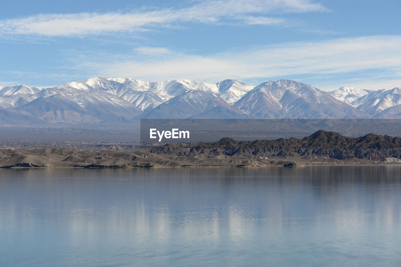 Scenic view of lake and snowcapped mountains against sky